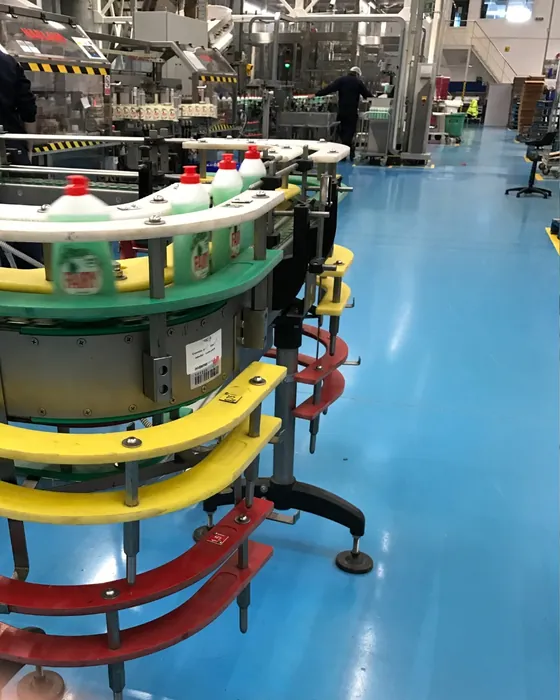 A filling line in operation, containers moving along a rotary transfer table towards the packing area.